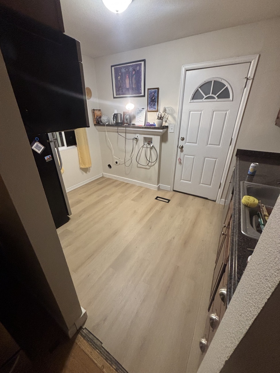 New vinyl plank flooring in a kitchen and laundry area